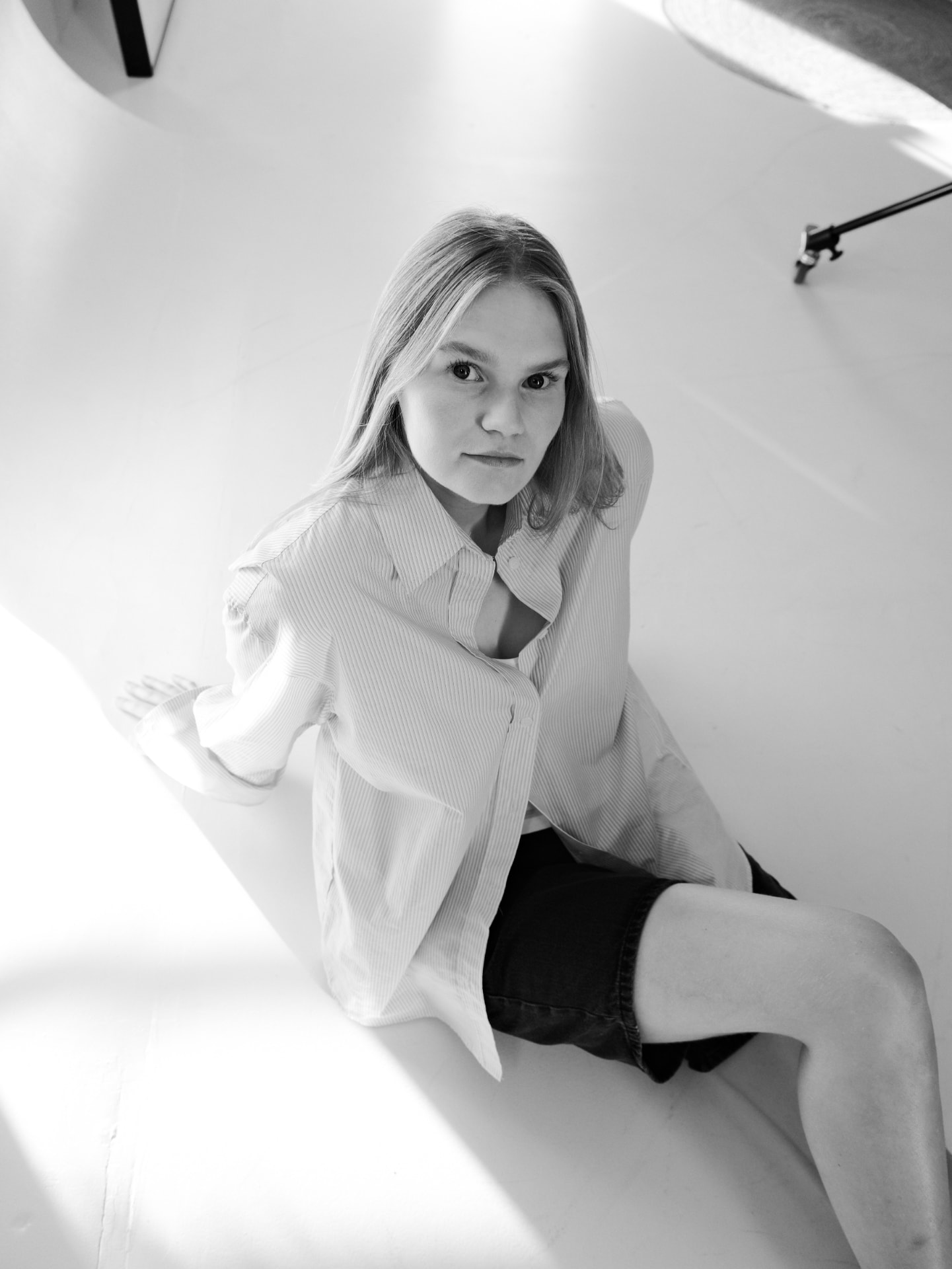 Svartvitt foto av Rebecka Norling sittande på studio golvet