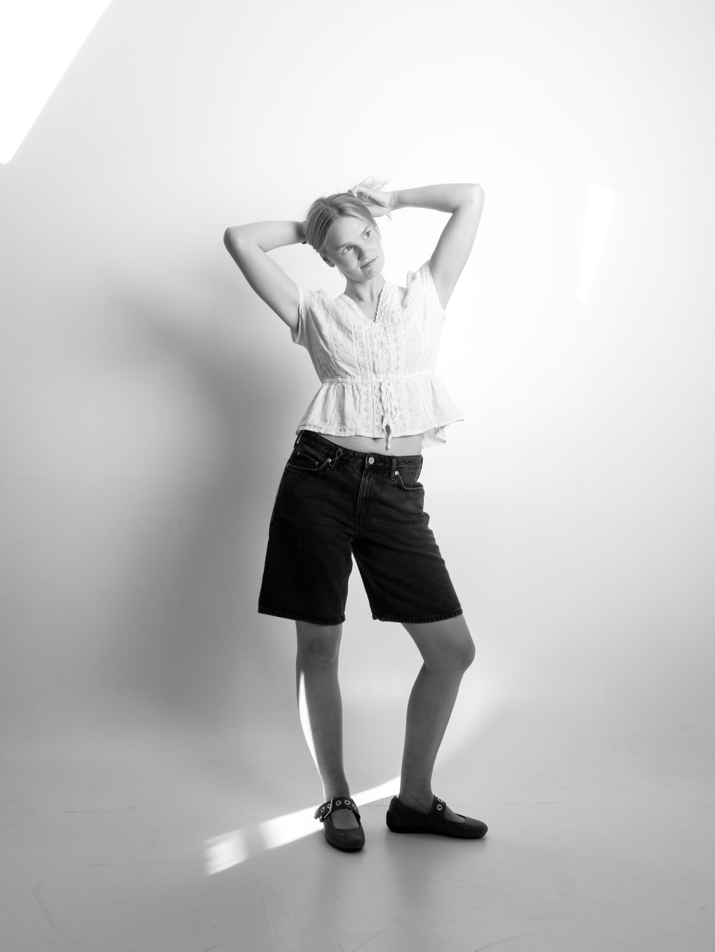 Svartvitt foto av Rebecka Norling i helfigur mot ljus studio bakgrund